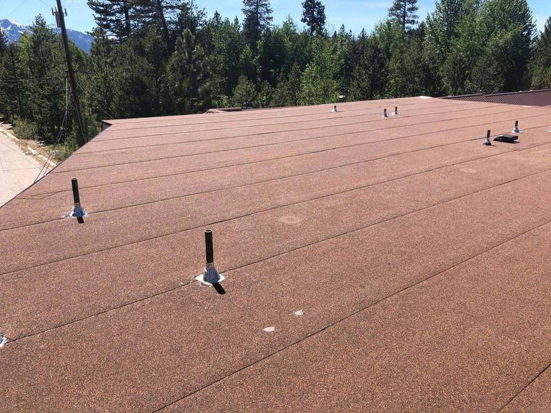 Brown torch-down modified bitumen flat roof with vent penetrations, installed by Trejo Heritage Roofing near Lake Tahoe