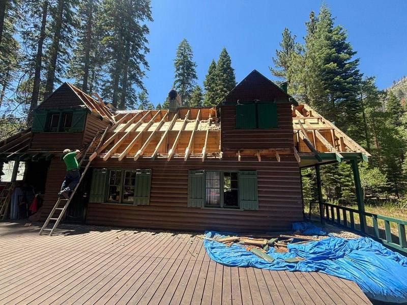 Log cabin roof stripped to the deck during a full roof replacement by Trejo Heritage Roofing