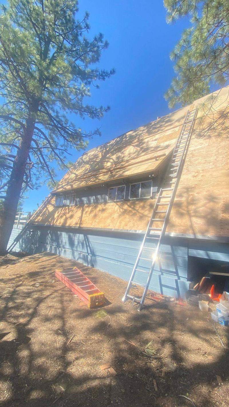 Roofer's ladder set against the roof edge of a South Lake Tahoe home during a repair